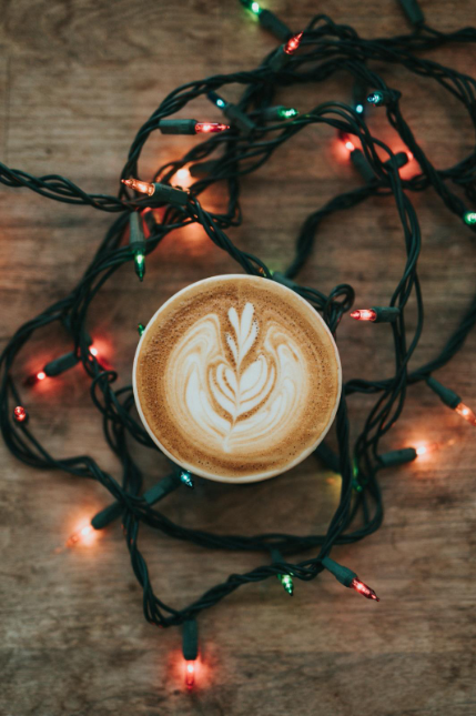 A latte cup surrounded by Christmas tree lights